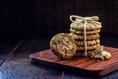 Tahıllı tam tahıllı kurabiye, kurutulmuş meyve ve eski ahşap masada çikolata.
