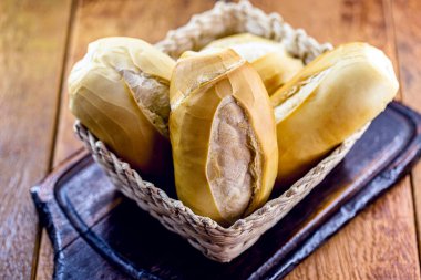 Çiğ ahşap arka planda Brezilya ekmeği sepeti. Geleneksel Brezilya kahvaltısı, Fransız ekmeği olarak bilinir..