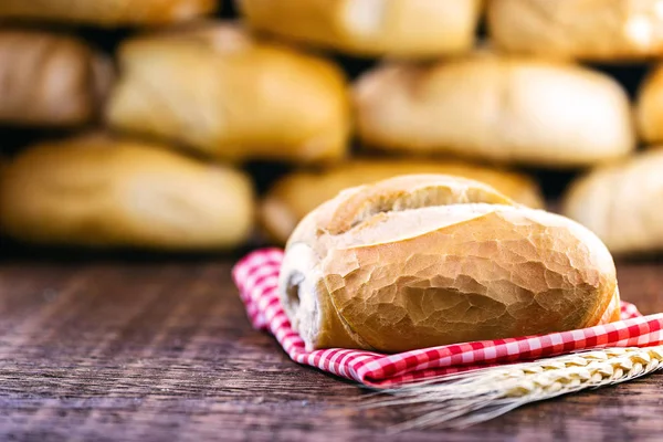 traditional Brazilian bread, called French bread, with an unfocused bakery background. National day of Brazilian French bread.