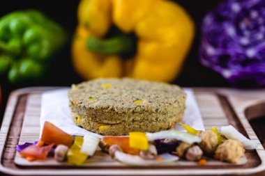 Etsiz ev yapımı vejetaryen hamburger. Renkli sebzelerle ahşap arka planda sebzelerden yapılıyor. Vejetaryen yaşam ve vejetaryen yaşam konsepti.