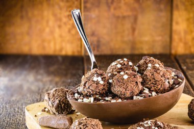 Tahta arka planda Paskalya için doldurulmuş çikolatalı yumurta. Seçici odaklanma, ahşap arka plan. Paskalya 2020.