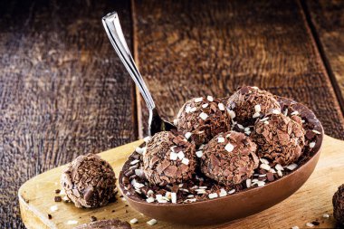 Tahta arka planda Paskalya için doldurulmuş çikolatalı yumurta. Seçici odaklanma, ahşap arka plan. Paskalya 2020.