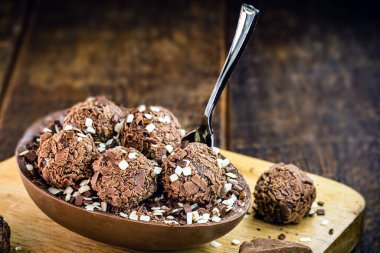 Tahta arka planda çikolatalı Paskalya yumurtası. Brezilya Paskalya konsepti. Kaşıklı çikolata göz..