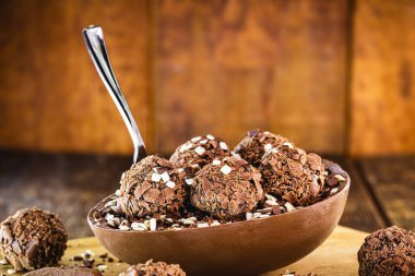 Tahta arka planda çikolatalı Paskalya yumurtası. Brezilya Paskalya konsepti. Kaşıklı çikolata göz..