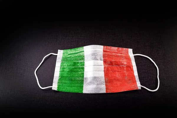 disposable respiratory mask with italy flag texture. Concept of coronavirus crisis in Italy, worldwide pandemic.