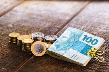 Brezilya parası ve 100 reais 'lik banknotlar. Kırsal ahşap arka plan, kanıtlanmış tasarruf kavramı veya büyük ödül.
