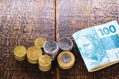 Brezilya sikkelerine ve 100 reais banknotlarına yakın plan, finans, Brezilya ekonomisi veya piyango.