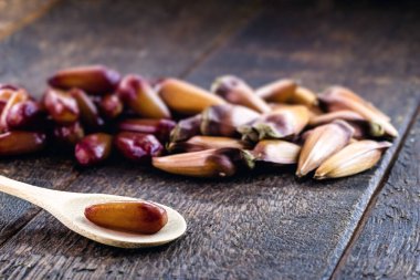 Brezilya çam fıstığı soyulmuş ve eski bir tahta kaşıkta pişirilmiş. Kırsal masa, sağlıklı ve vegan mutfağı..