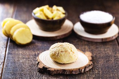 Hayvan ürünleri olmadan Brezilya 'da yapılan vejetaryen peynirli ekmek, tapyoka (manyok unu) ve patates kullanılır. Kırsal ahşap arka planda organik ürünler.