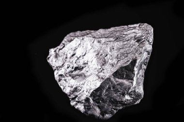 Çiğ manganez. Manganez taşı siyah arkaplanda izole edilmiş. Ağır metallerin mineral çıkarımı.