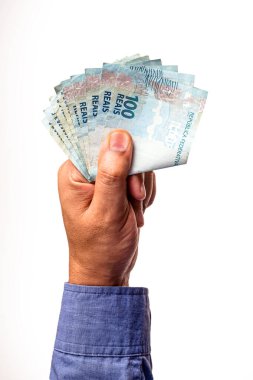 Brezilya 'nın 100 reais banknotları izole beyaz arka planda erkek eliyle tutuluyor. Ödül parası veya kişisel kazanç kavramı.