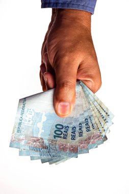 Brezilya 'nın 100 reais banknotları izole beyaz arka planda erkeğin elinde..