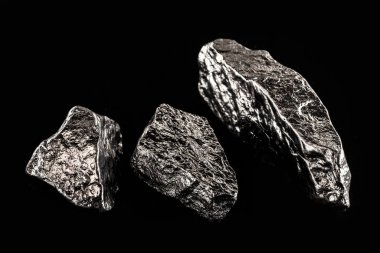 Siyah izole edilmiş arka planda teneke taş. Sanayi uygulaması cevheri.