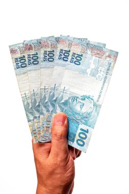 Brezilya 'dan 100 reais banknot, izole edilmiş beyaz arka planda erkek eliyle tutulmuş. Brezilya 'dan 100 reais' in banknotları, ödeme günü..