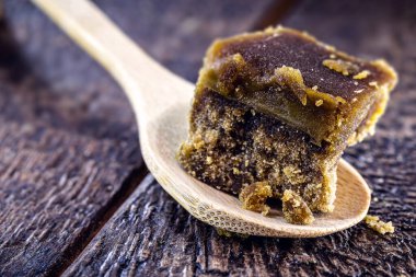 Kırsal ahşap bir kaşıkta tatlı esmer şeker. Brezilya ve Latin Amerika 'nın tatlı tipik şeker kamışından yapılmış