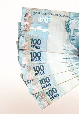Brezilya 'dan 100 reais banknot, izole edilmiş beyaz arka planda erkek eliyle tutulmuş. Brezilya 'dan 100 reais' in banknotları, ödeme günü..