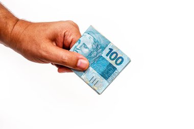 Brezilya 'dan 100 reais banknot, izole edilmiş beyaz arka planda erkek eliyle tutulmuş. Brezilya 'dan 100 reais' in banknotları, ödeme günü..
