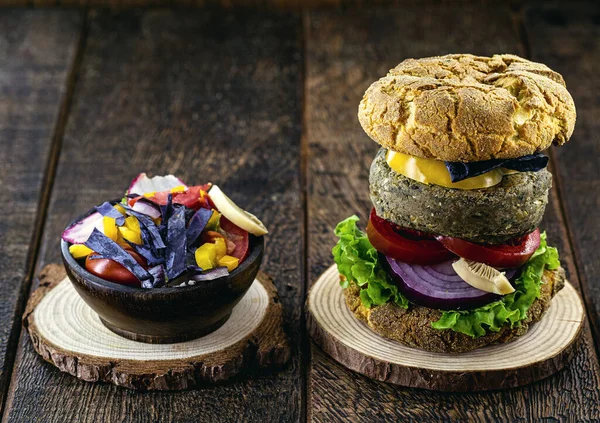 vegan meal, meatless hamburger, gluten free, made with different vegetables and proteins. Brown bread on gourmet hamburger, rustic background.