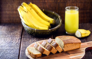 Glütensiz vejetaryen ekmeği ve hayvansal ürünler yok. Vejeteryan ekmeği, muz aromalı, kırsal bir masada, dilimlenmiş ve servis etmeye hazır.