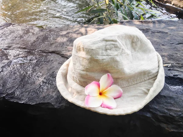 Cappello con fiore su roccia fluviale con fondo ruscello trasparente — Foto Stock