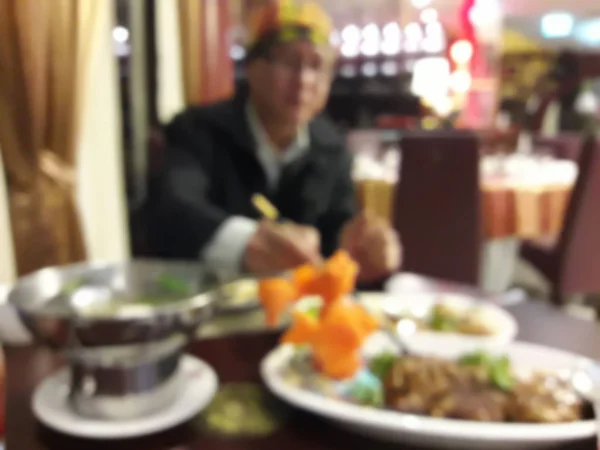 背景をぼかした写真の男性がアジア スタイルのレストランで食べて — ストック写真