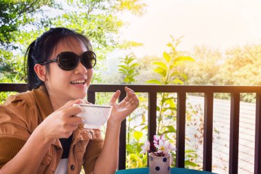 Asya siyah saçlı kız ya da kadın mutlu sırasında kahve tim gülümseyen