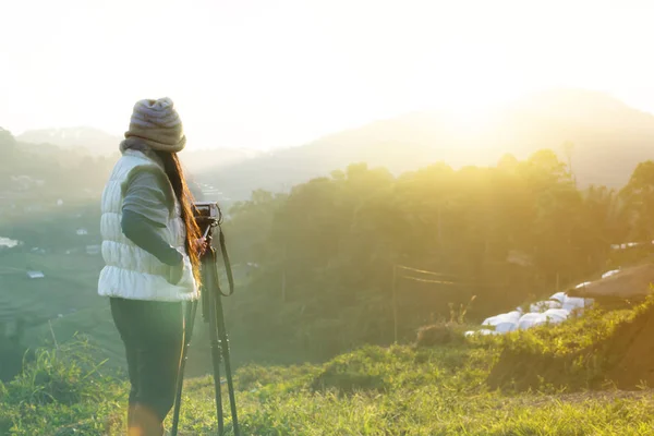 Tillbaka eller sällsynta kvinnor skytte sunrise på berget i gröna na Stockbild