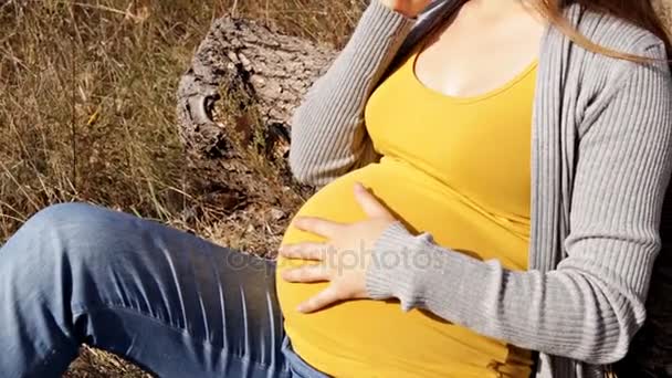 Молода вагітна жінка говорить по телефону — стокове відео