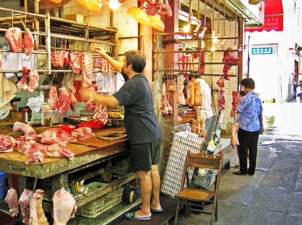 Carniceros venden carne fresca a un cliente en una tienda de centeno de carne abierta en Hong Kong —  Fotos de Stock