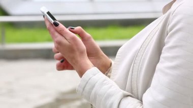 Smartphone kullanarak gülen kız portresi. Cep telefonu çeşme arka plan üzerinde olan genç ve güzel kadın. Şehir Parkı, atış Steadicam Smartphone kullanan oldukça mutlu kadın.