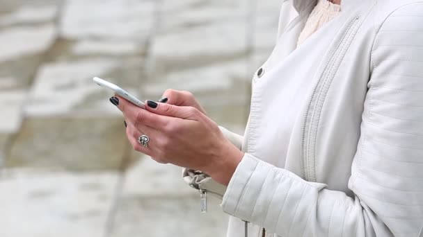 Portret van meisje lachen met behulp van de smartphone. Mooie jonge vrouw met haar mobiele telefoon op de achtergrond van de fontein. Vrij gelukkig vrouw met behulp van smartphone in stadspark, Steadicam schot. — Stockvideo