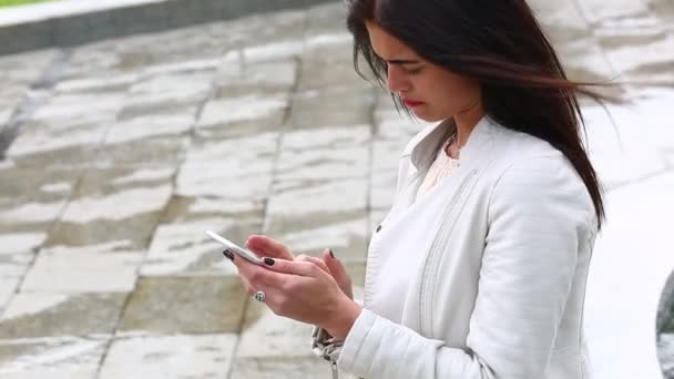 Retrato de niña riendo usando smartphone. Mujer joven y bonita con su teléfono móvil en el fondo de la fuente. Mujer bastante feliz utilizando el teléfono inteligente en el parque de la ciudad, Steadicam tiro . — Vídeos de Stock