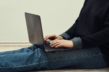 katta oturan ve dizüstü kullanan kadın