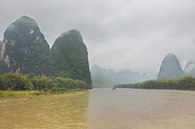 Guilin yakınlarındaki Yangshuo civarındaki Xingpingzhen balıkçı köyünü geçerken Li Nehri Vadisi 'nin geniş bir manzarası var.