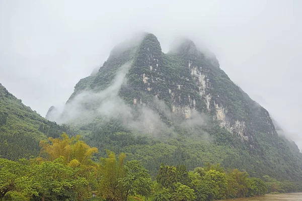高密度の雲の丘の李川の近くに桂林の近くの陽朔の境界上に忍び寄る — ストック写真