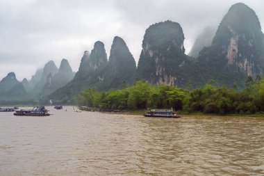 Guilin yakınlarındaki Yangshuo civarındaki Xingpingzhen balıkçı köyünde Li Nehri 'nde yoğun bir trafik var.