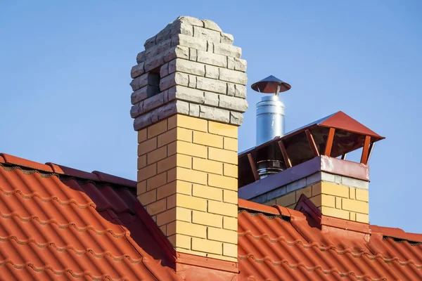 Brick pipe on the roof of a private house.