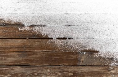 Arkaplan olarak açık bir terasın tahta zemininde kar var..