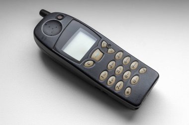 Eski hücresel tuşlu telefon beyaz pencere pervazına yakın plan.