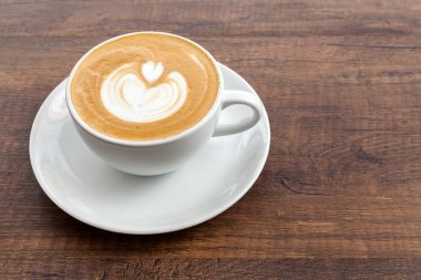 Latte sanat kopya alanı ahşap zemin üzerine kahve fincanı