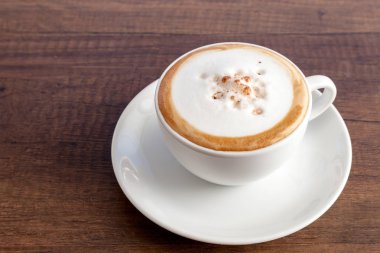 Kopya alanı ile ahşap arka plan üzerinde cappuccino kahve fincan