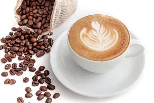 Kaffekopp rosetta latte art med kaffebönor bredvid, på whi — Stockfoto