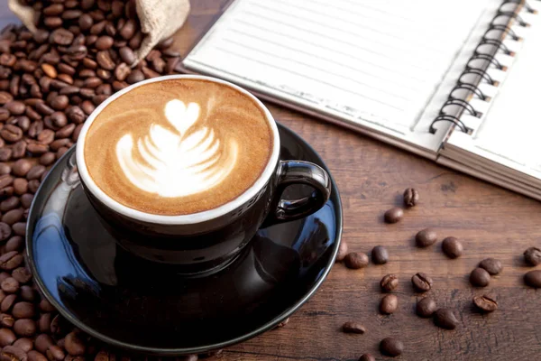 Kaffeetasse Latte Art in der schwarzen Farbtasse mit etwas Kaffee — Stockfoto