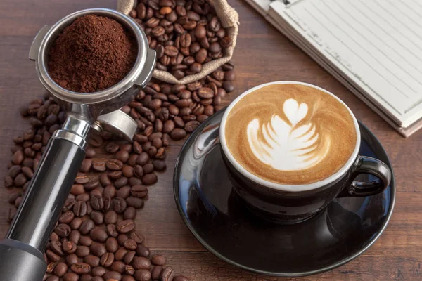 Xícara de café de arte latte no copo de cor preta com um pouco de café — Fotografia de Stock