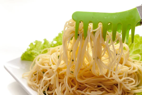 Gotowane spaghetti gotowe służyć na płytki biały, backgro biały — Zdjęcie stockowe