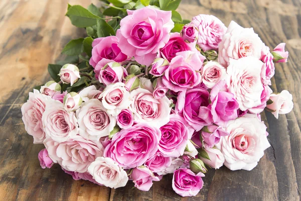 Ramo de rosas rosadas en una mesa de madera rústica —  Fotos de Stock