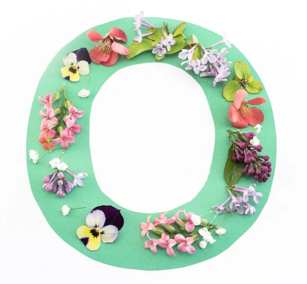 Buchstabe o aus Frühlingsblumen und Papier — Stockfoto