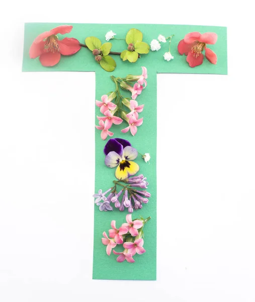 Dopis T vyrobená z jarních květin a papíru — Stock fotografie