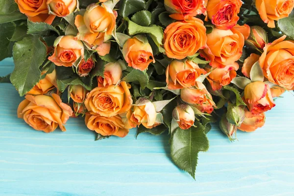 Mavi bir arka plan üzerinde turuncu gül buketi
