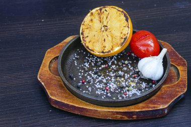 Izgara limon, domates ve sarımsak bir dökme demir fryin içinde otlar ile